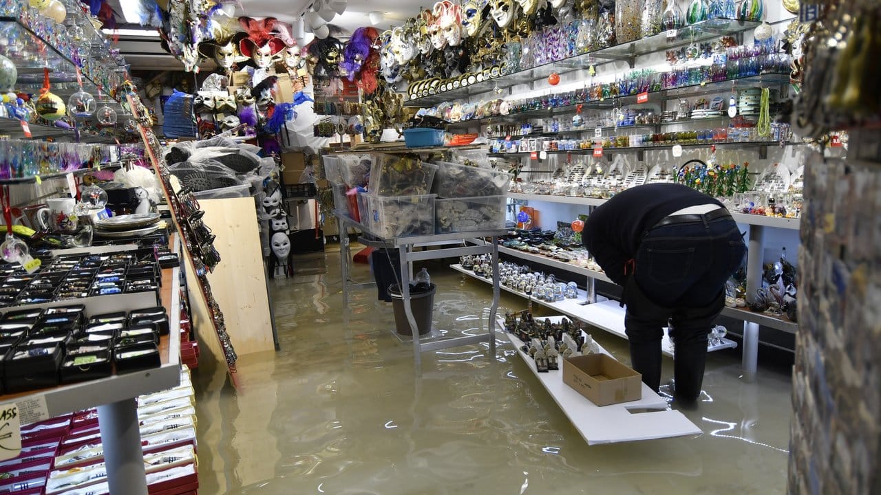 Ein Ladenbesitzer überprüft in seinem überfluteten Souvenirgeschäft die Schäden.
