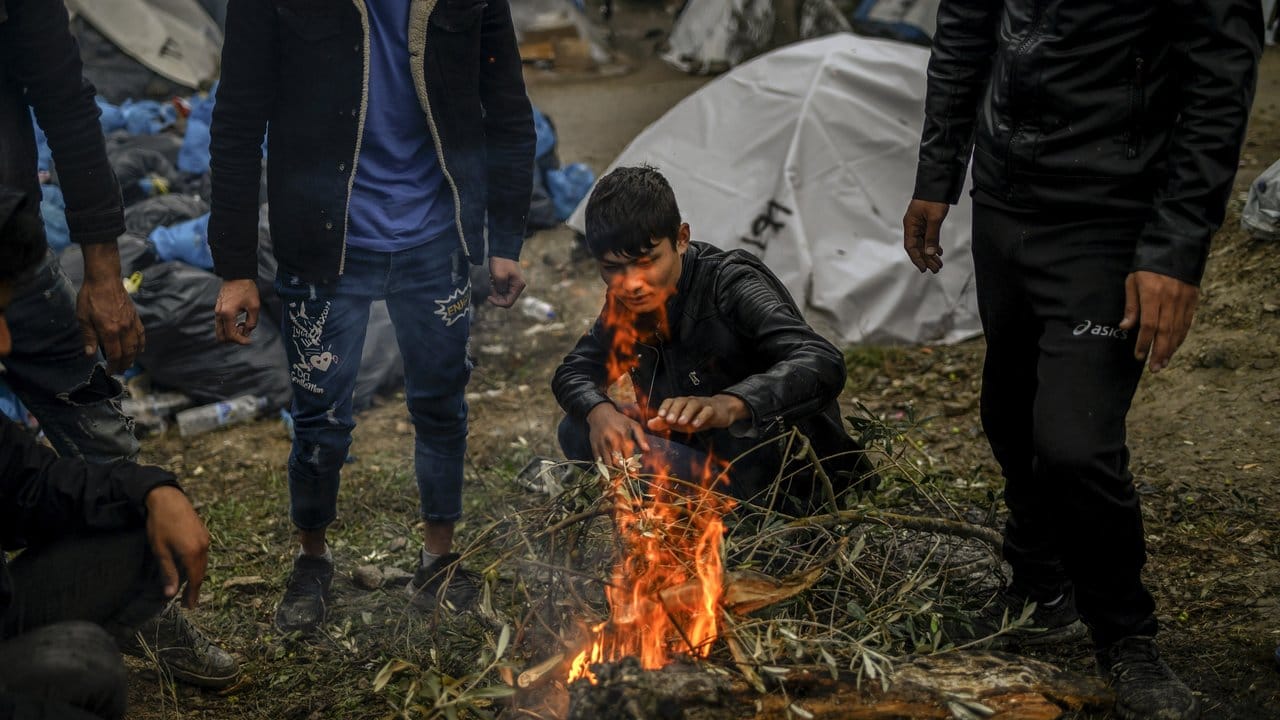 Migranten versuchen sich an einem kleinen Feuer neben dem Lager Moria auf der Insel Lesbos aufzuwärmen.