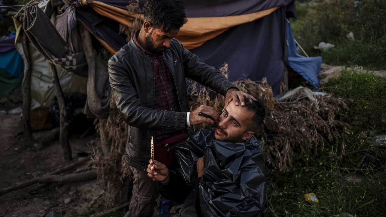 Ein Mann rasiert einen anderen Flüchtling im Flüchtlingslager auf der griechischen Insel Samos.