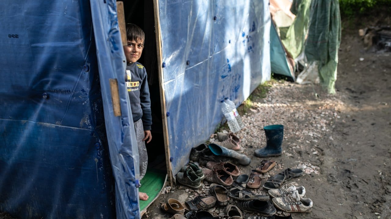 Ein Kind schaut aus einem Zelt im Flüchtlingslager Vial.