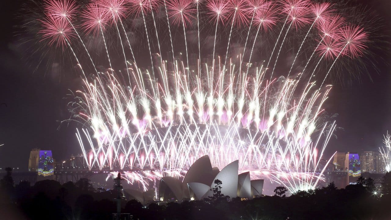Ein Feuerwerk explodiert am Himmel über der Oper und der Harbour Bridge während der Neujahrsfeierlichkeiten in Sydney.