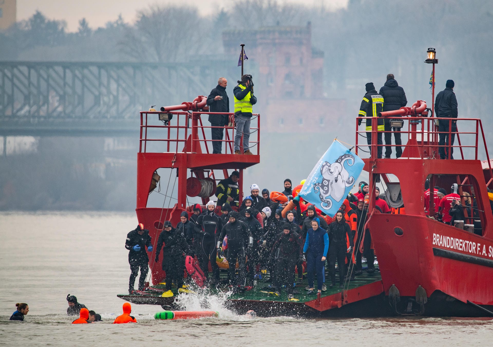 Zahlreiche Taucher springen von einem Schiff in den Rhein: In Mainz verabschieden Seenotretter so das alte Jahr – und wollen auf ihre besonderen Aufgaben hinweisen.