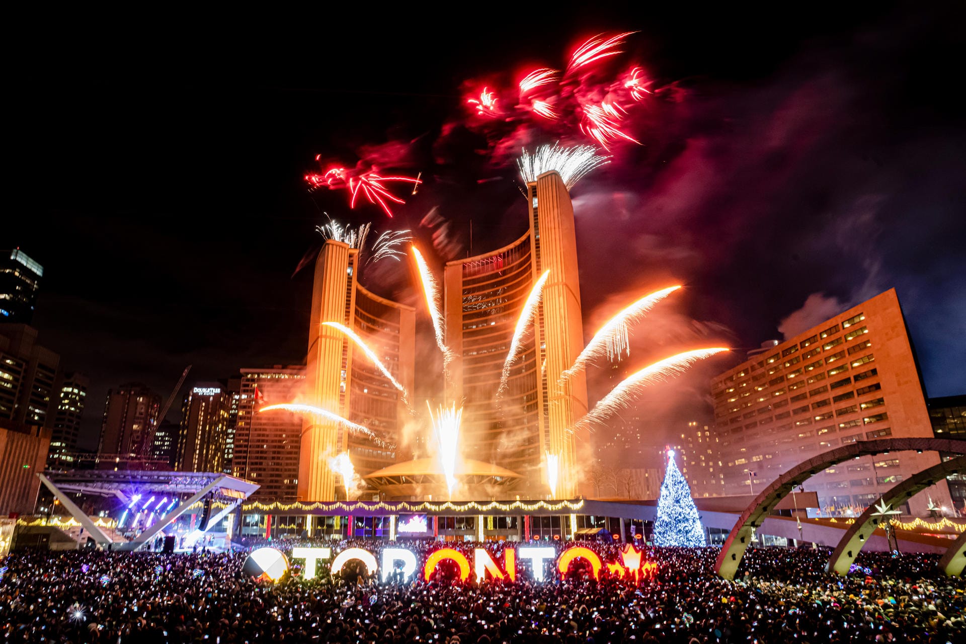 Toronto: Menschen schauen sich um Mitternacht auf dem Nathan Philips Square das Neujahrsfeuerwerk an.