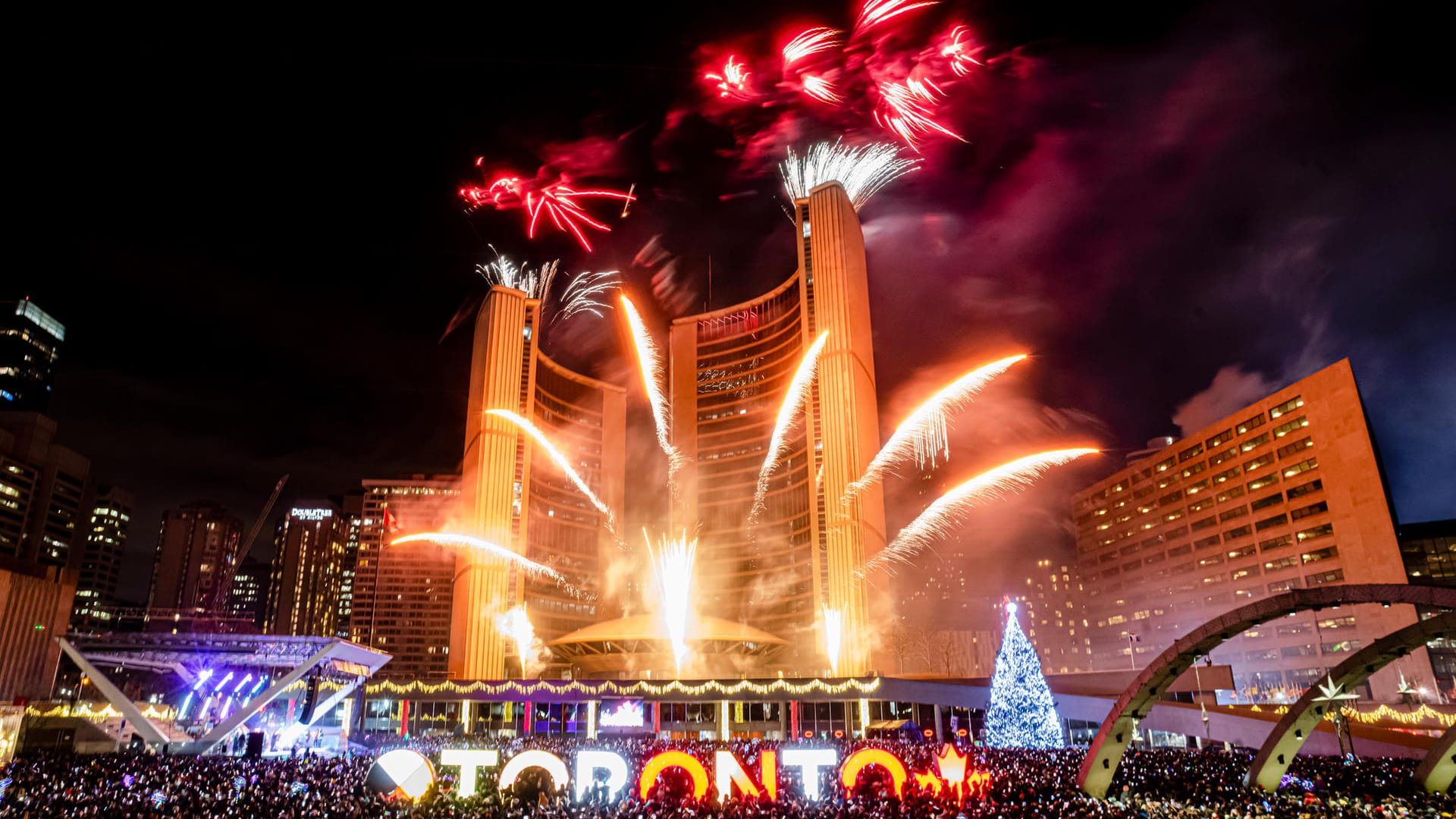 Toronto: Menschen schauen sich um Mitternacht auf dem Nathan Philips Square das Neujahrsfeuerwerk an.