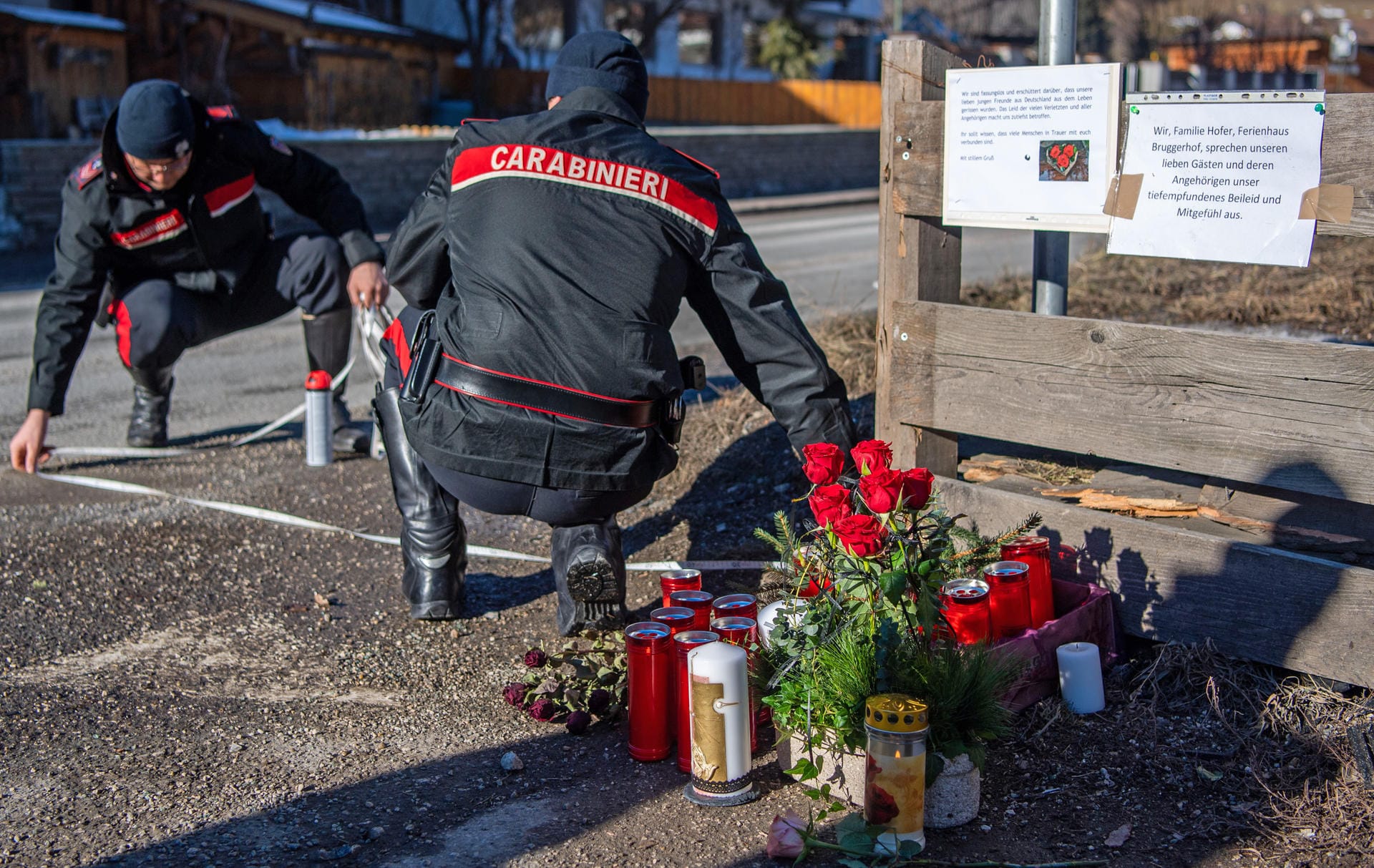 Die Ermittlungen dauern an. Hier rekonstruieren zwei Einsatzkräfte der Carabinieri rekonstruieren den Unfallhergang. Blumen, Kerzen und Gedenkschmuck liegen am Ort des Unfalls. Die Ermittlungen dauern an. Hier rekonstruieren zwei Einsatzkräfte der Carabinieri rekonstruieren den Unfallhergang. Blumen, Kerzen und Gedenkschmuck liegen am Ort des Unfalls.