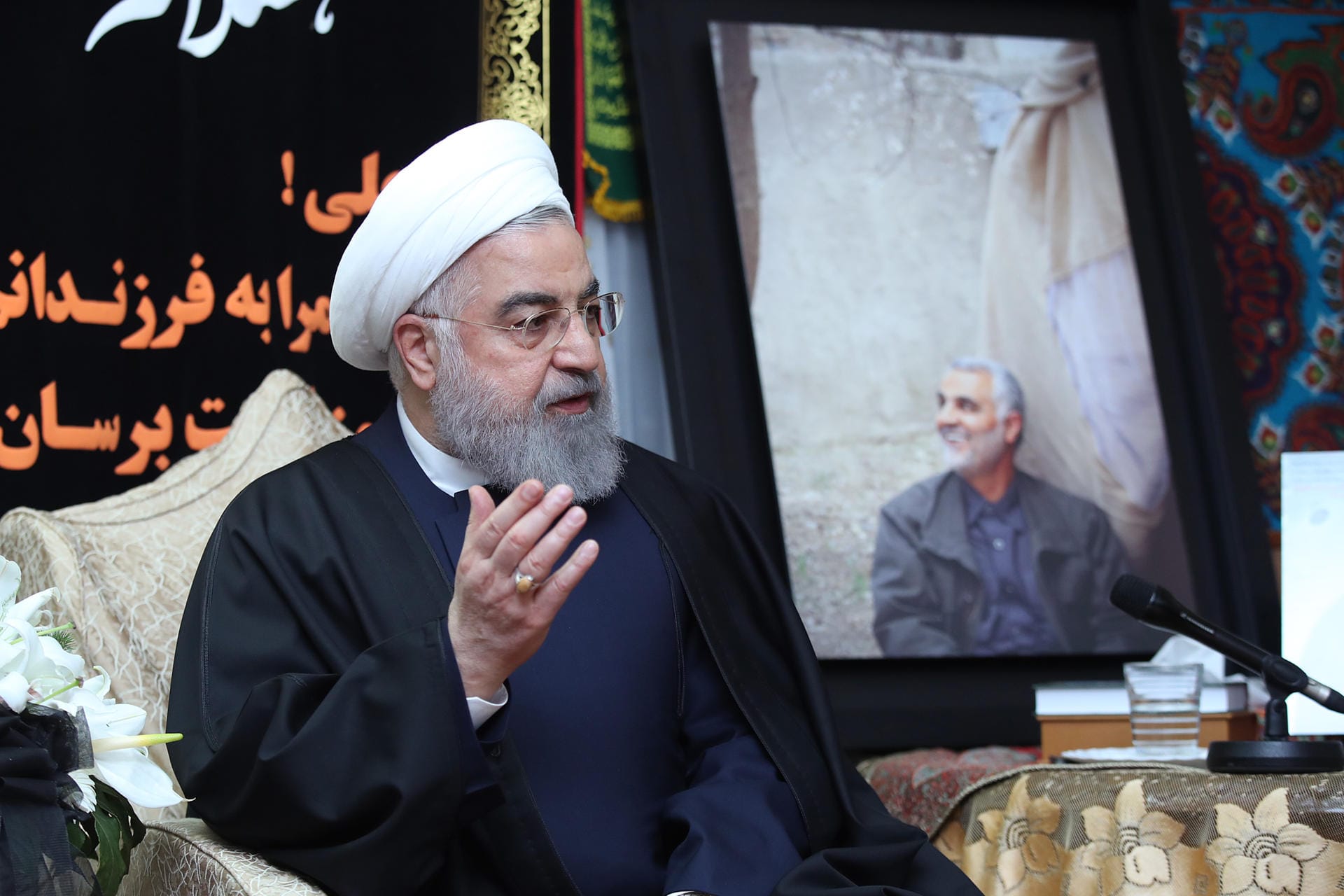 3. Januar 2020: Irans Präsident Hassan Ruhani neben einem Bild von Soleimani. Der Oberste Nationale Sicherheitsrat des Iran droht den USA "schwere Vergeltung am richtigen Ort zur richtigen Zeit" an. Der "kriminelle" Angriff auf General Soleimani sei "der größte Fehler", den die USA in der Region begangen hätten".