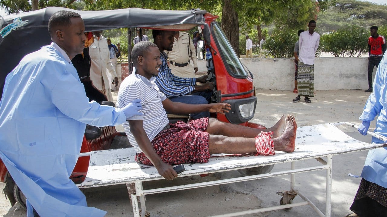 Sanitäter helfen einem Mann, der bei dem Autobombenanschlag in Mogadischu verletzt wurde.