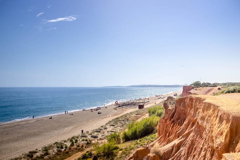 Praia da Falésia: Nur einige Meter hinter dem portugiesischem Strand befinden sich rote Sandsteinfelsen, die mit Pinien bewachsen sind.