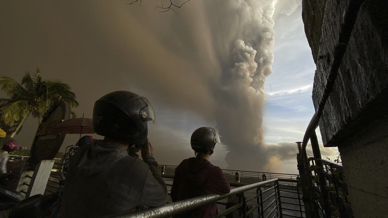 Menschen beobachten die riesigen Rauchwolken.