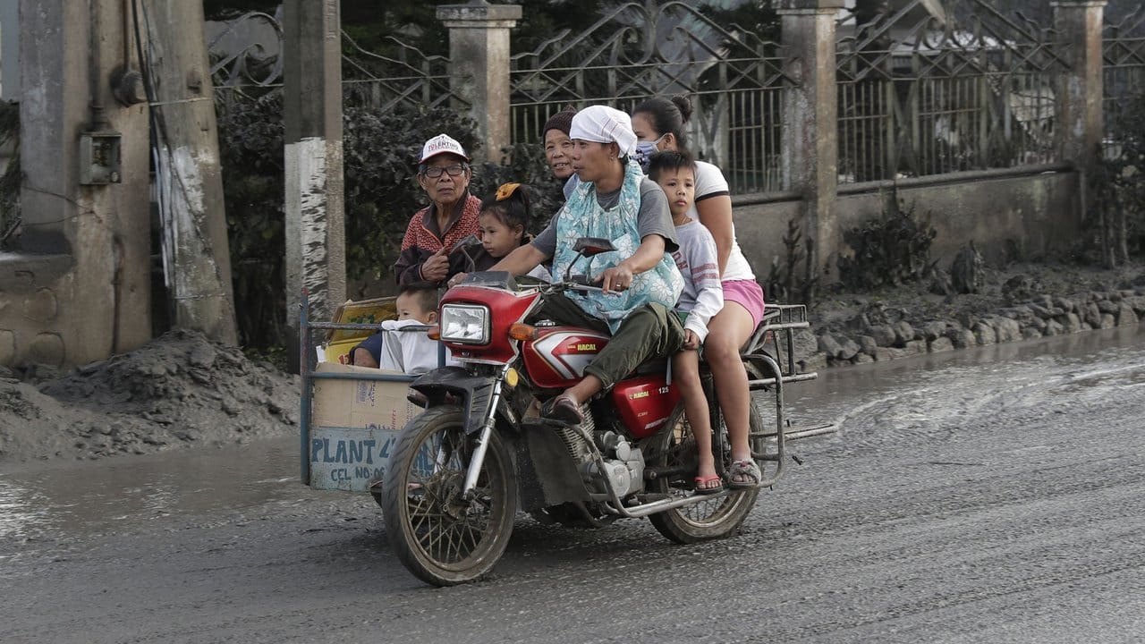 Eine Familie verlässt die Region auf einem Motorrad samt Beiwagen.