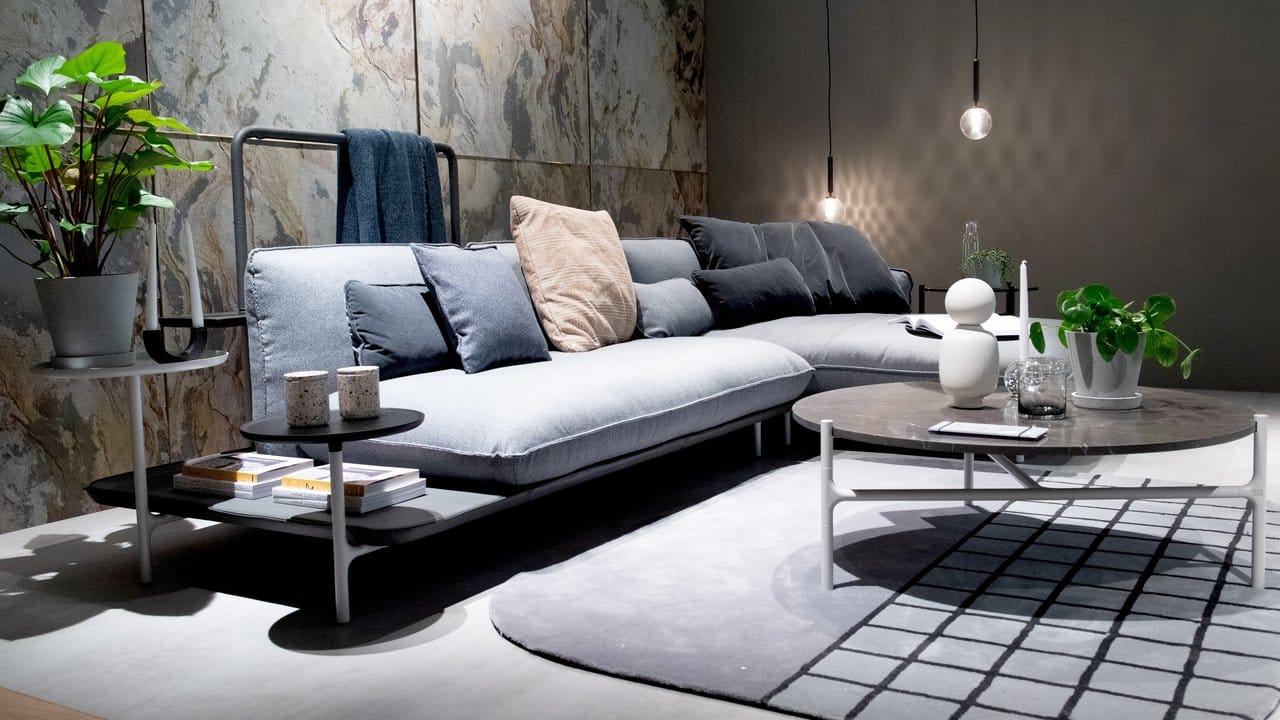 Designer nutzen eine Farbfamilie: Das kieselgraue Sofa mit integrierter Ablagefläche kombiniert der Hersteller Rolf Benz mit dunkelgrauen Kissen.