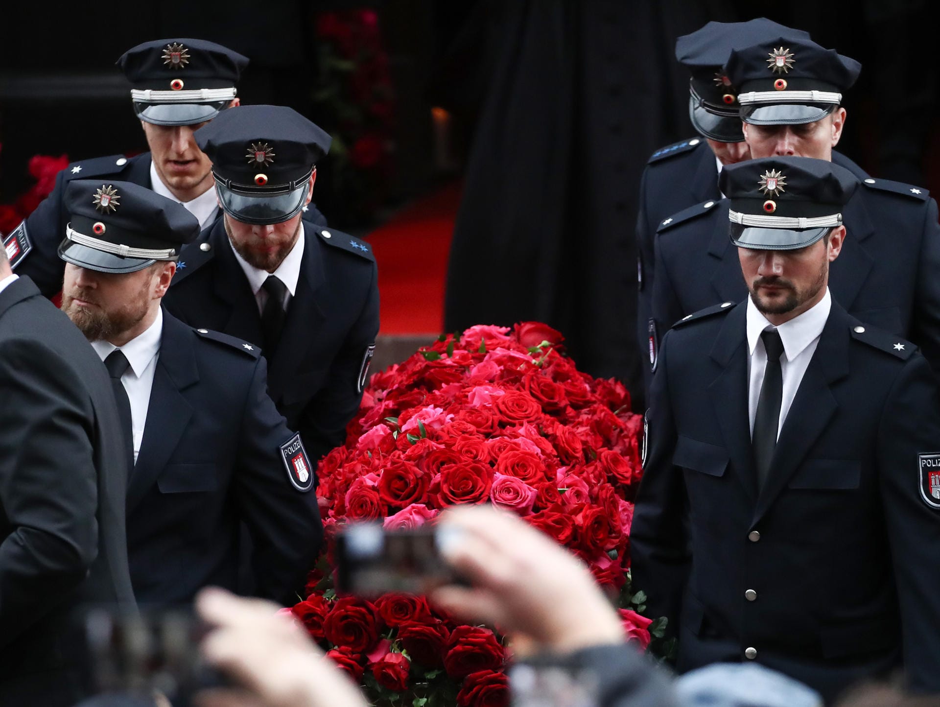 Der Sarg mit dem Leichnam des Schauspielers Jan Fedder wird nach der Trauerfeier von Polizisten aus der Kirche getragen