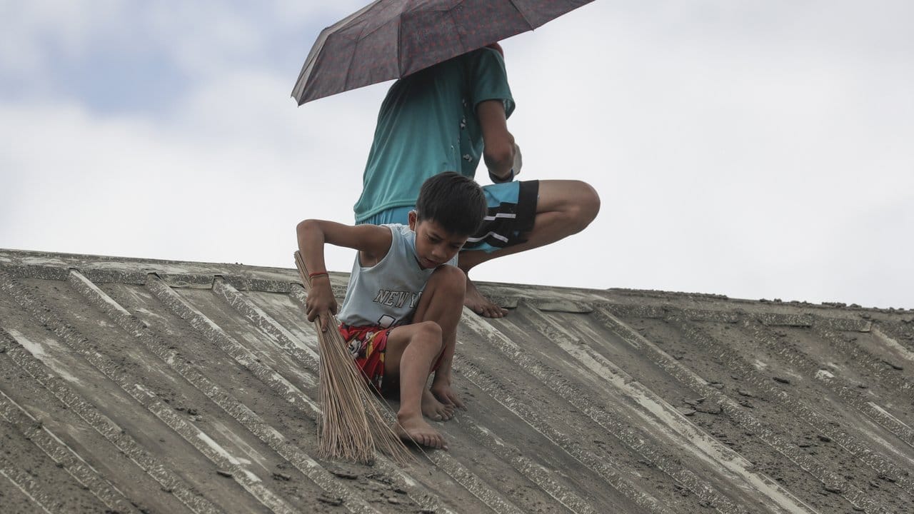 Saubermachen: Ein Junge hilft seiner Familie dabei, Vulkanasche vom Dach ihres Hauses in der Provinz Batangas zu entfernen.