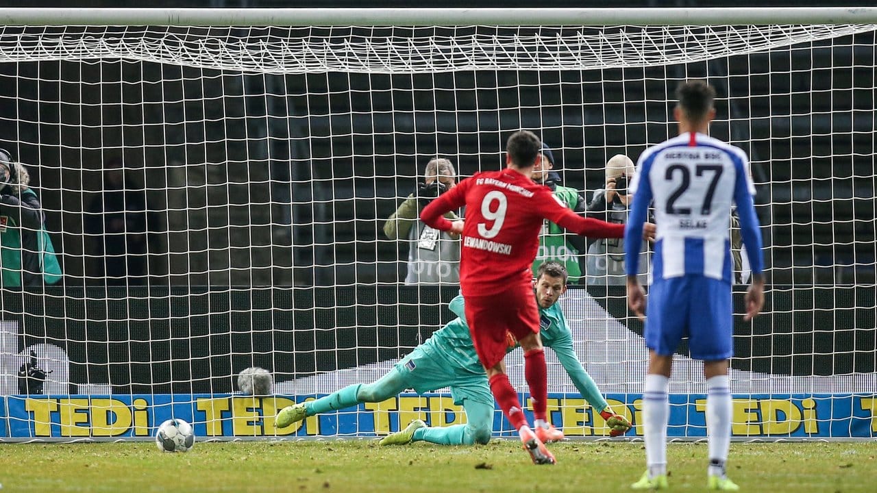 Bayerns Robert Lewandowski (l) verwandelt einen Elfmeter zum 2:0.