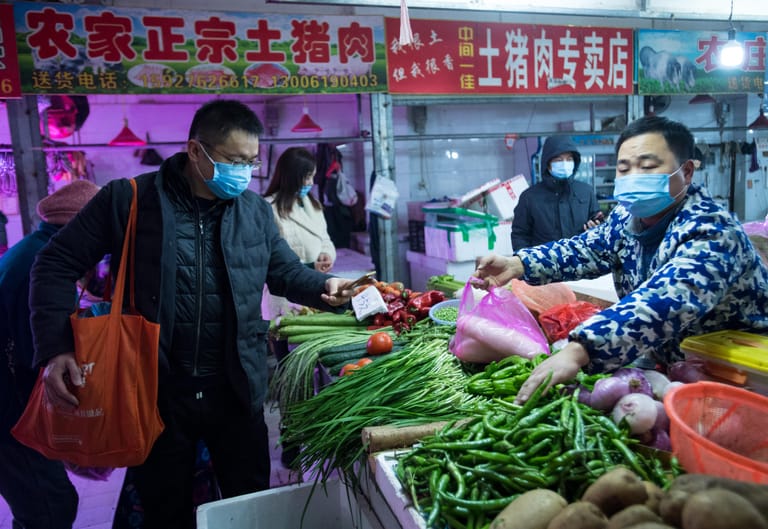 Bürger kaufen Gemüse auf einem Markt in Wuhan. Die chinesische Regierung hat die besonders schwer von der neuen Lungenkrankheit betroffene Millionenmetropole praktisch abgeriegelt.