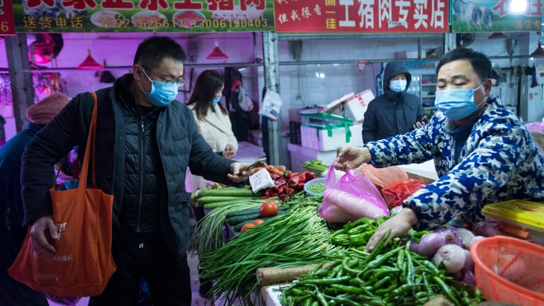 Bürger kaufen Gemüse auf einem Markt in Wuhan. Die chinesische Regierung hat die besonders schwer von der neuen Lungenkrankheit betroffene Millionenmetropole praktisch abgeriegelt.