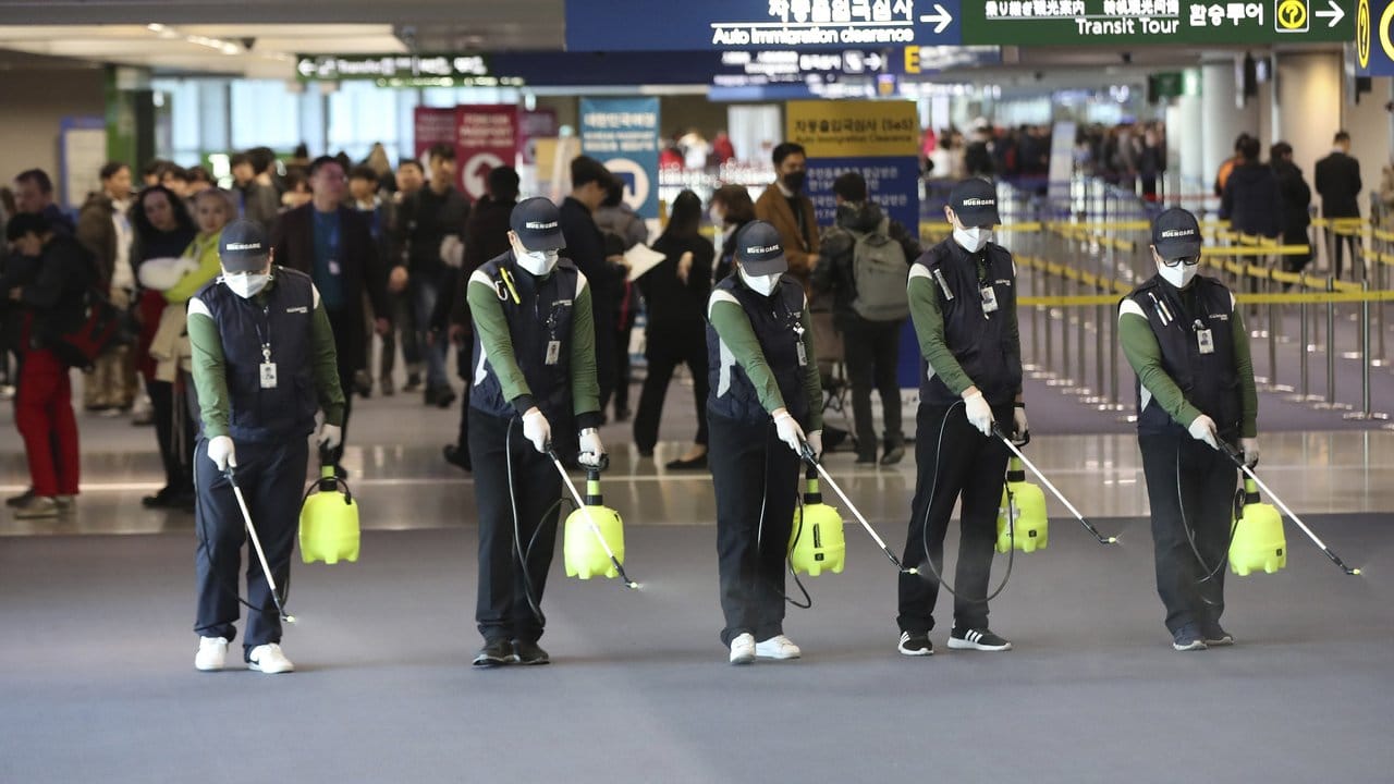 Flughafenpersonal sprüht im südkoreanischen Flughafen Incheon International eine keimtötende Lösung. Flughafenpersonal sprüht im südkoreanischen Flughafen Incheon International eine keimtötende Lösung.