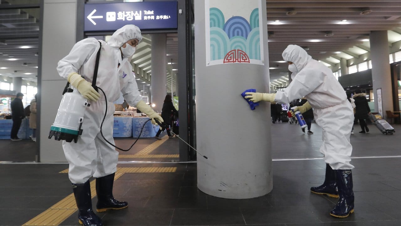 Mitarbeiter versprühen in einem Bahnhof in Seoul vorsorglich ein Desinfektionsmittel.