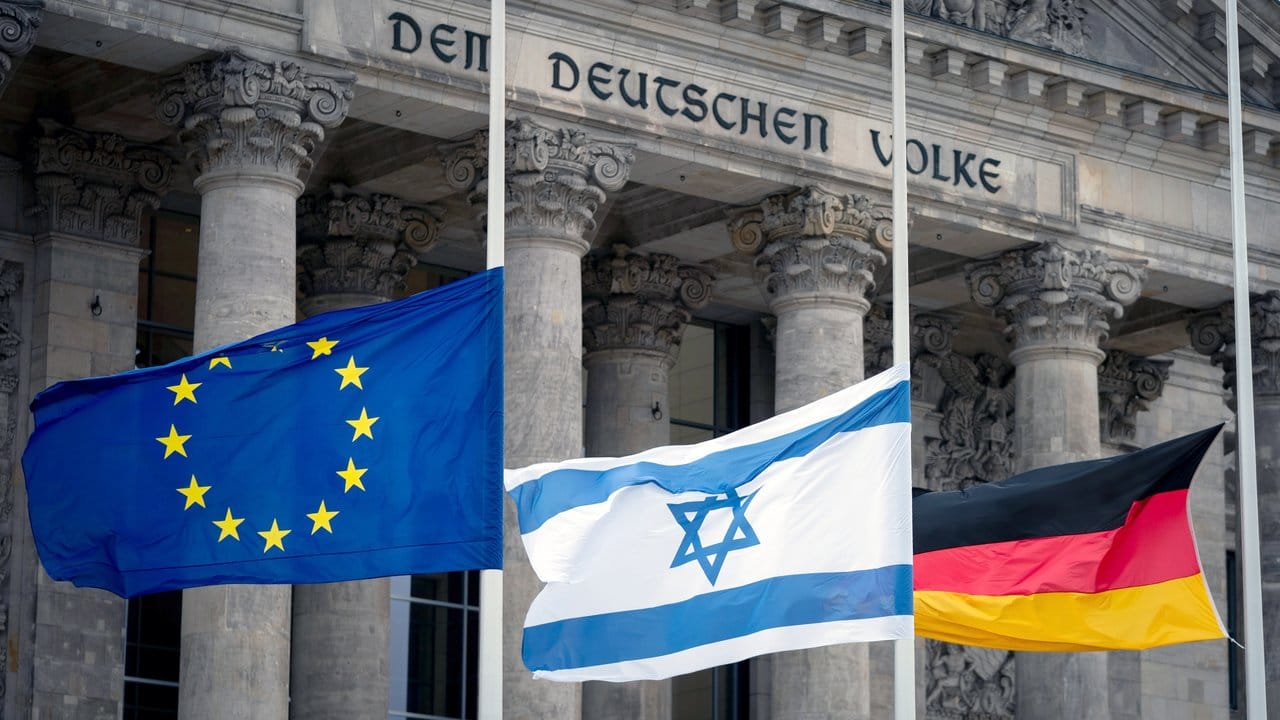 Die Fahnen der EU, von Israel und von Deutschland wehen vor dem Reichstagsgebäude auf Halbmast.
