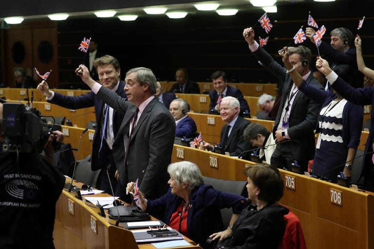 Sie freuen sich: Die Brexit-Befürworter um Nigel Farage winken mit kleinen Fähnchen im EU-Parlament.