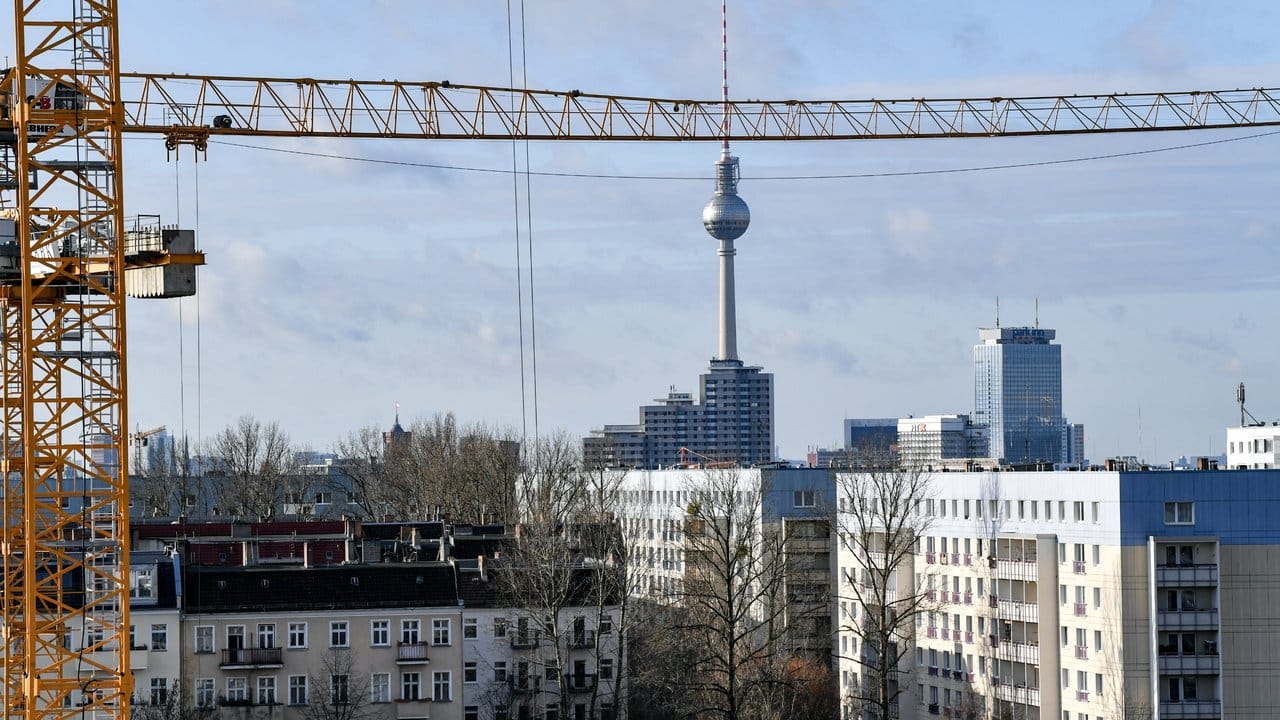 Der Fernsehturm am Alexanderplatz ist hinter Baukränen und Mietshäusern zu sehen.