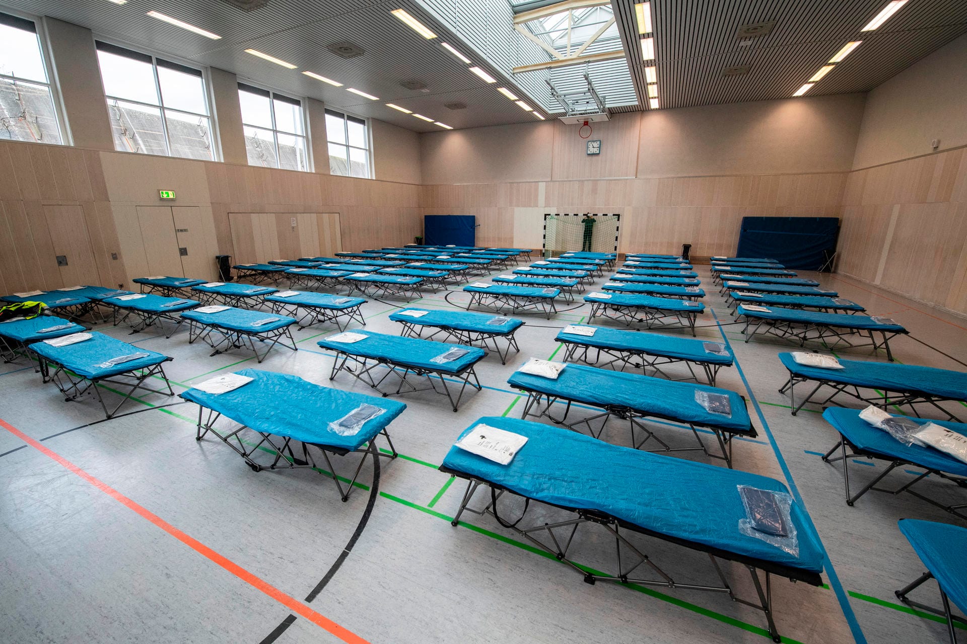 Dutzende Feldbetten stehen in einer Turnhalle auf dem Gelände des Flughafens in Frankfurt für die Ankunft von rund 90 Menschen bereit. Dutzende Feldbetten stehen in einer Turnhalle auf dem Gelände des Flughafens in Frankfurt für die Ankunft von rund 90 Menschen bereit.