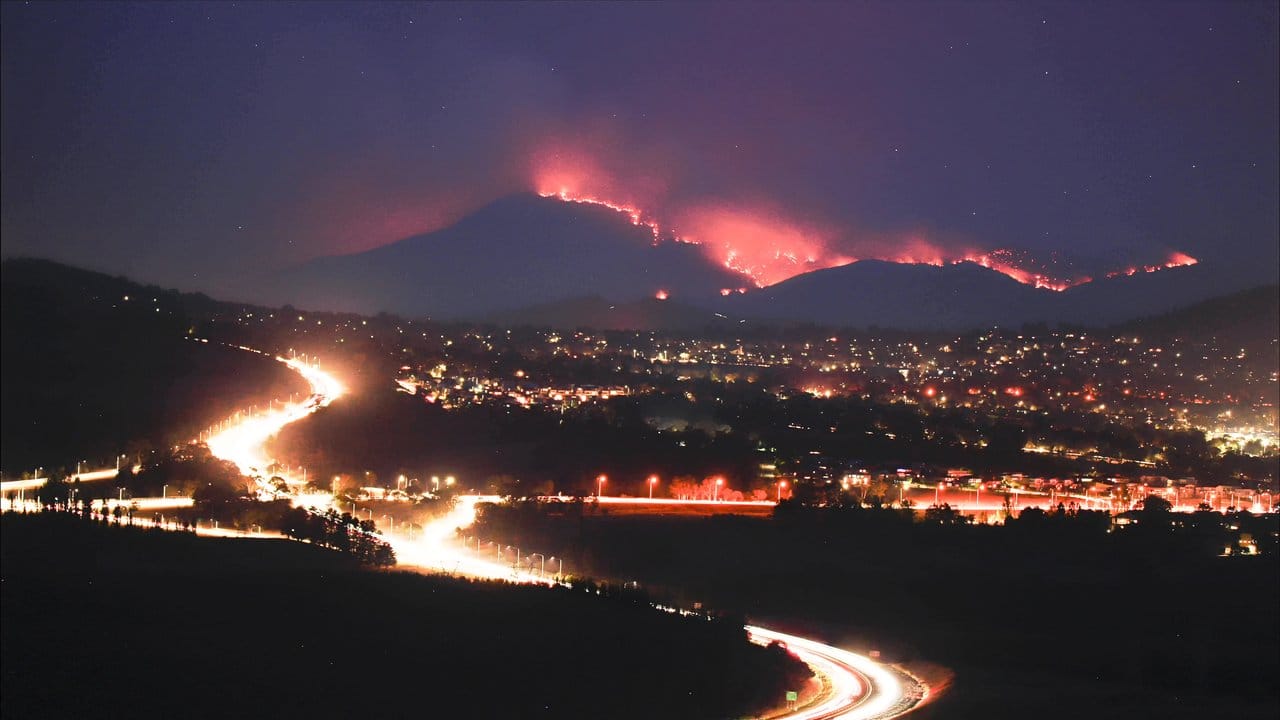 Die Buschfeuer im Orroral Valley südlich von Canberra leuchten in der Dunkelheit in den Hügeln. Die Buschfeuer im Orroral Valley südlich von Canberra leuchten in der Dunkelheit in den Hügeln.