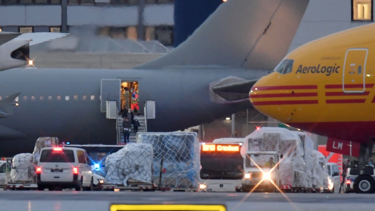 Passagiere verlassen das Flugzeug mit Schutzmasken. Passagiere verlassen das Flugzeug mit Schutzmasken.