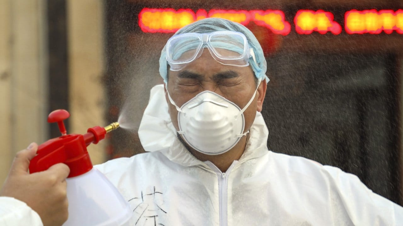 Ein Helfer in einer Quarantänestation in Wuhan wird desinfiziert. Ein Helfer in einer Quarantänestation in Wuhan wird desinfiziert.
