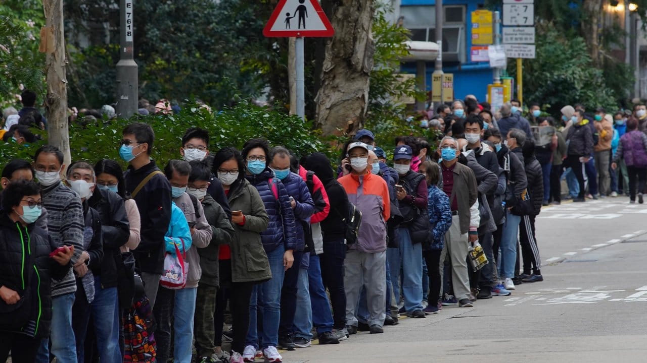 Menschen stehen in Hongkong an, um Schutzmasken zu kaufen.