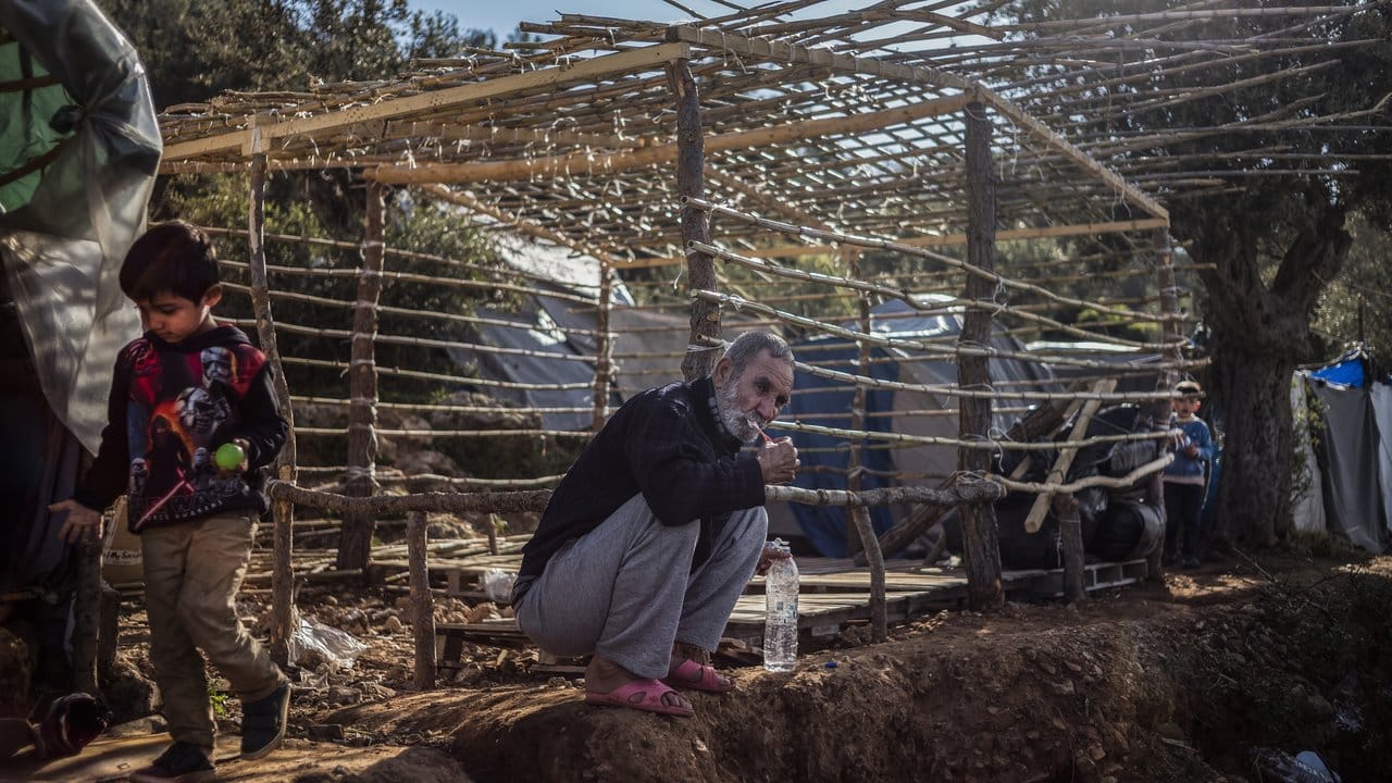 Ein Flüchtling putzt sich vor dem Gerüst seiner einfachen Hütte im Flüchtlingslager auf der griechischen Insel Samos die Zähne.