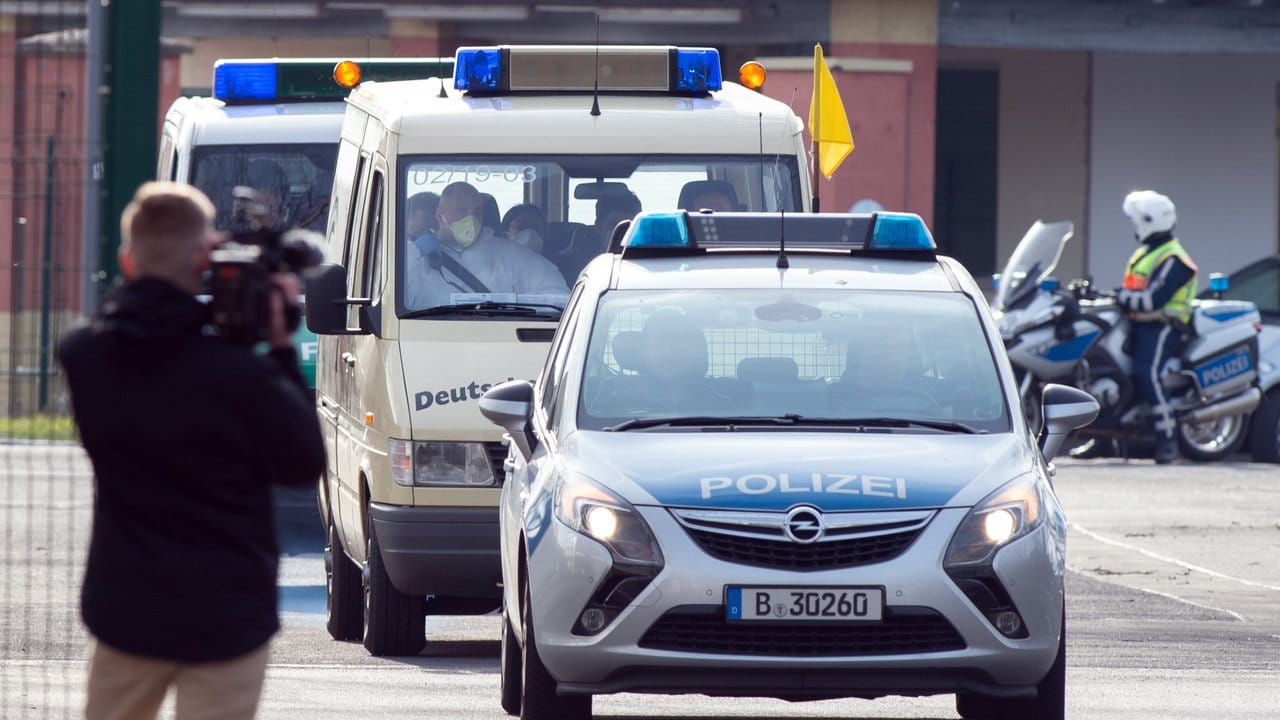 Von Polizei eskortiert verlassen Krankenwagen mit den China-Rückkehrern den militärischen Teil des Flughafens Tegel.