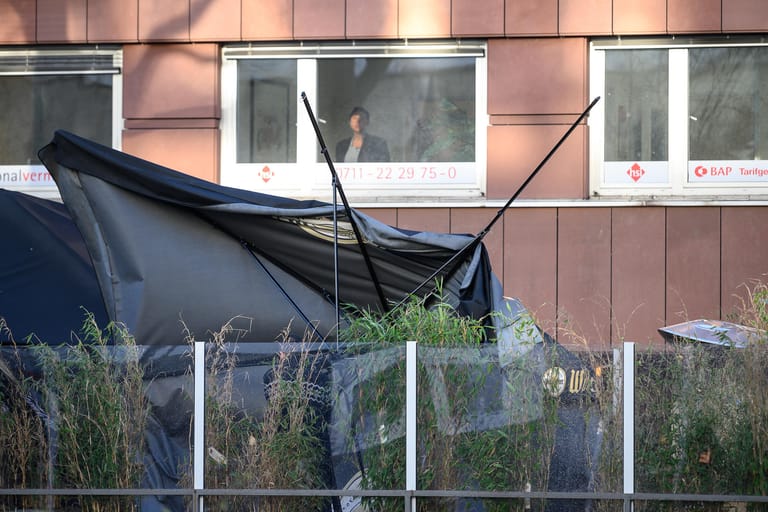 Stuttgart: Der Schirm eines Restaurants wird während Sturmtief "Sabine" von einem Mitarbeiter zusammen gepackt, nachdem dieser kaputt gegangen ist.