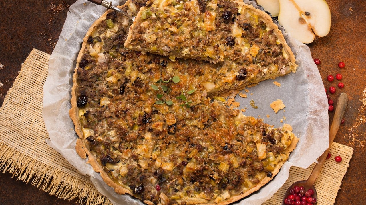 Würziger Käse und Birnen harmonieren bei der Birnentarte mit Hackfleisch, Preiselbeeren sowie Frisch- und Bergkäse.