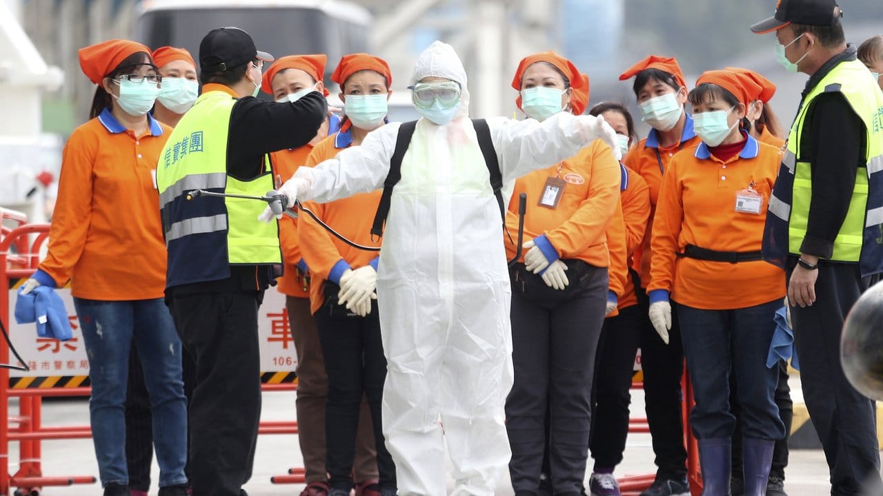 Ein Mitarbeiter der Seuchenbekämpfung steht bereit, um im Hafen von Taiwans Hauptstadt Taipeh an Bord des Kreuzfahrtschiffes "SuperStar Aquarius" zu gehen.