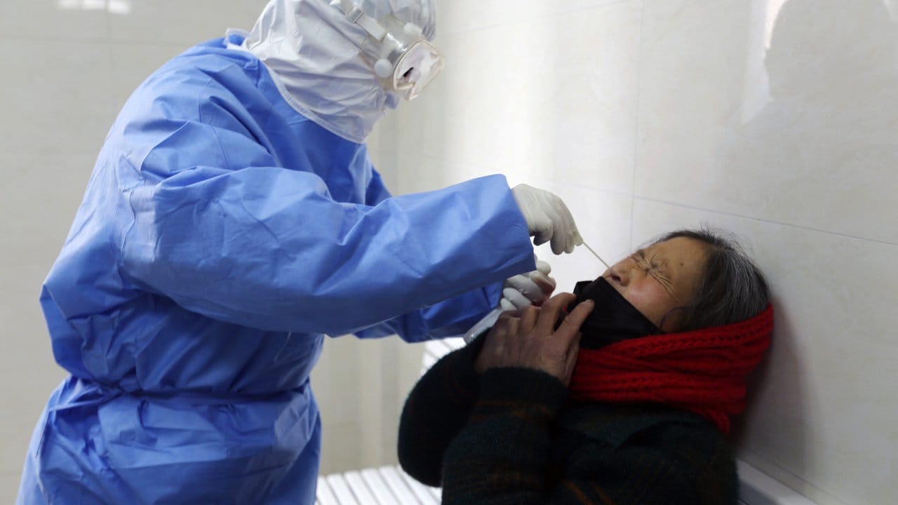 Test auf das Covid-19-Virus: Ein Arzt nimmt in einer Fieberklinik in der ostchinesischen Provinz Shandong einen Abstrich bei einer Frau.