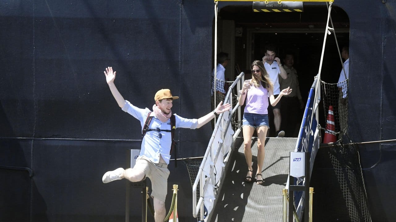 Passagiere reagieren voller Freude, während sie das Kreuzfahrtschiff "Westerdam" im Hafen von Sihanoukville verlassen.