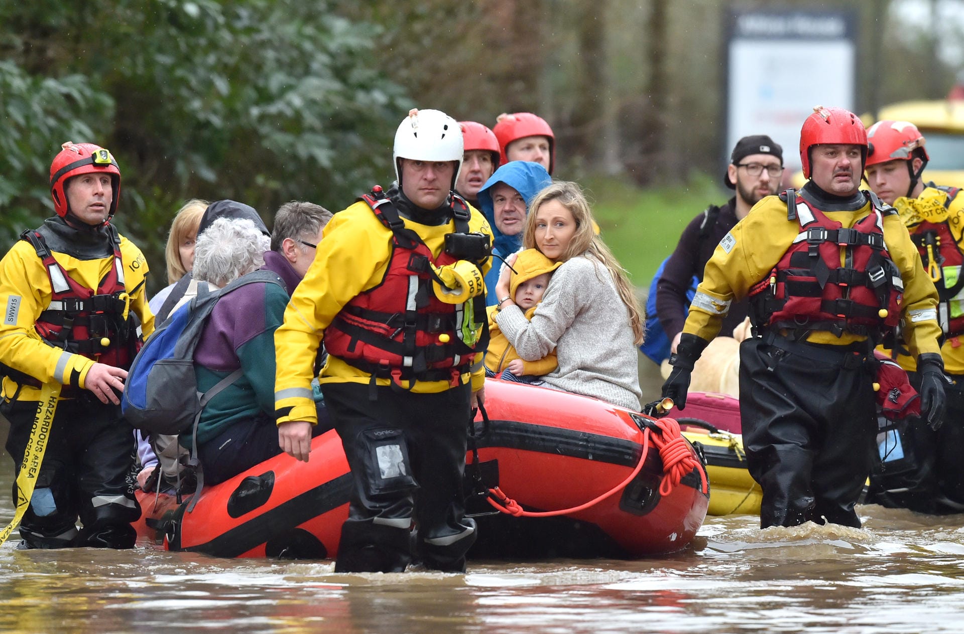 Im Dörfchen Nantgarw in Wales bringen Rettungskräfte eine Anwohnerin mit ihrem kleinen Sohn und weiteren Dorfbewohnern per Schlauchboot in Sicherheit.