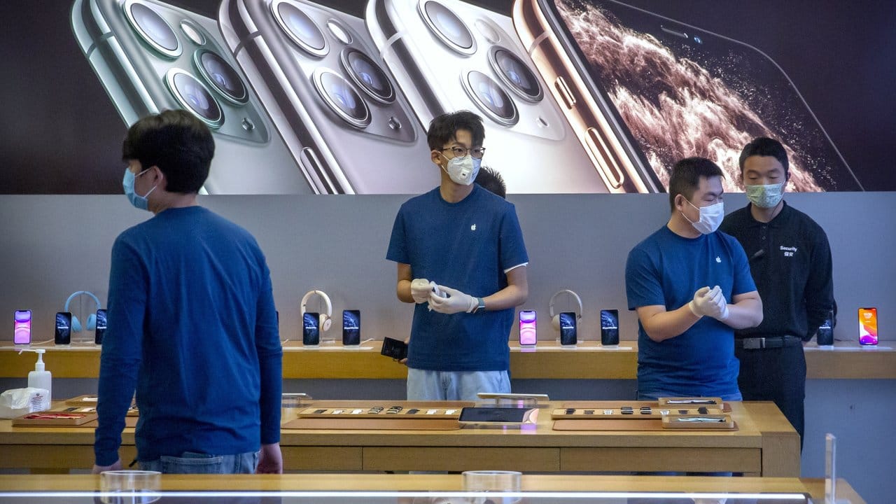 Dieser Apple-Store in Peking hat zwar wieder geöffnet, die Mitarbeiter schützen sich aber trotzdem weiter mit Mundschutz und Handschuhen.