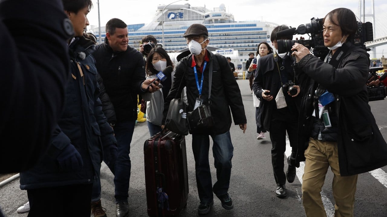 Endlich an Land: Ein Passagier wird von Journalisten empfangen, nachdem er das Kreuzfahrtschiff "Diamond Princess" verlassen hat.
