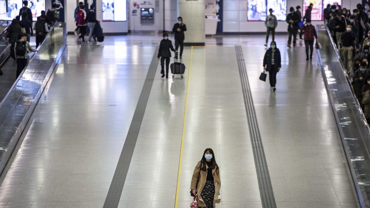 Pendler in Hongkong tragen Mundschutz in einer U-Bahnstation.