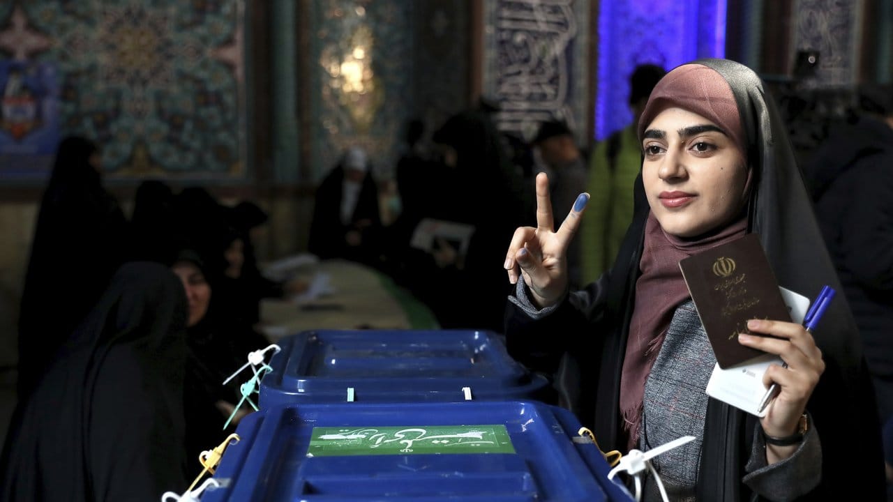 Eine Wählerin zeigt mit eingefärbten Fingern ein Siegeszeichen, während sie in Teheran ihre Stimme abgibt.