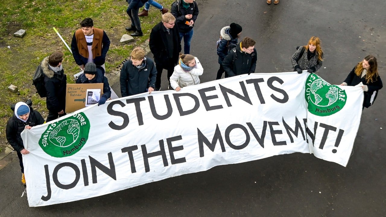 Teilnehmer der Klima-Demonstration von Fridays for Future tragen ein Transparent mit der Aufschrift "Students join the movement".