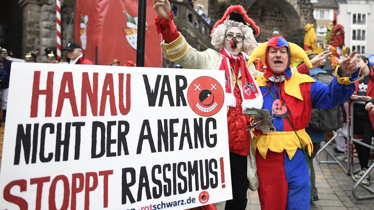 Karnevalisten erinnern vor Beginn des Rosenmontagszuges an die schrecklichen Ereignisse in Hanau.