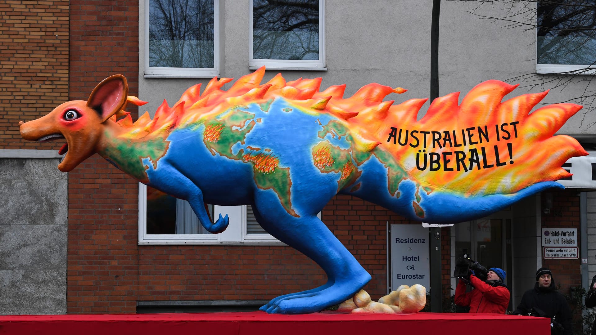 Ein Motivwagen zu dem Buschbränden in Australien "Australien ist überall!" steht auf der Straße vor dem Rosenmontagszug: Mit den Rosenmontagszügen erreicht der rheinische Straßenkarneval seinen Höhepunkt.