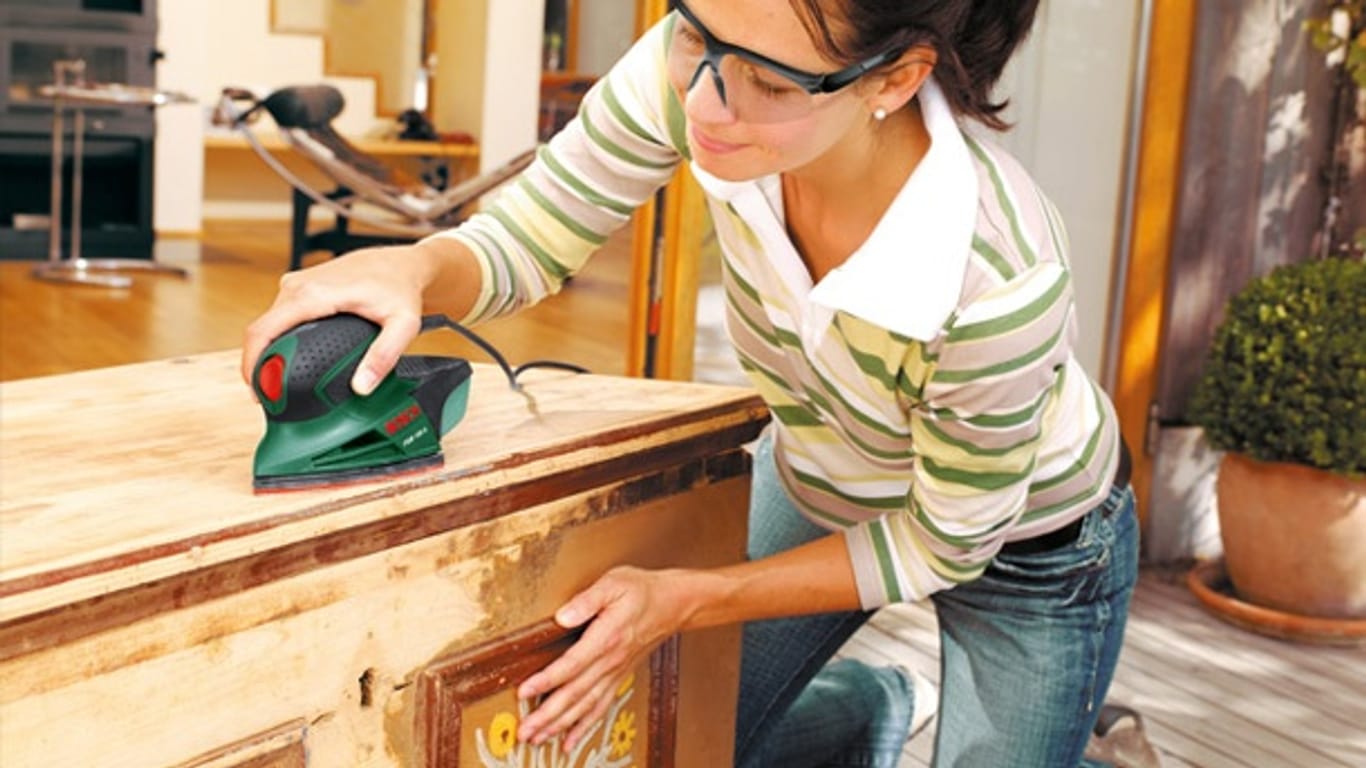 Vor dem Beizen Holz abschleifen: Sie können das Material mit Schleifpapier oder mit Schleifgeräten bearbeiten.