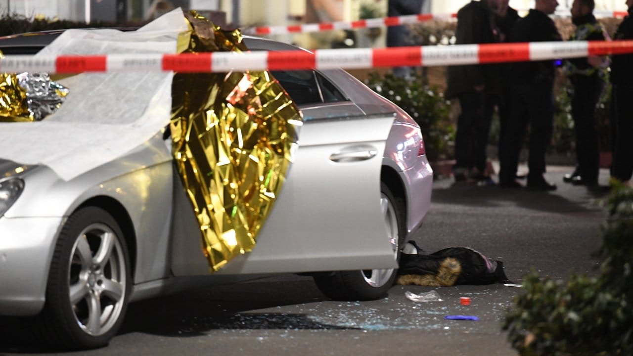 Ein Auto ist mit Thermofolie abgedeckt, neben dem Wagen liegen Glassplitter und eine Jacke. Ein Auto ist mit Thermofolie abgedeckt, neben dem Wagen liegen Glassplitter und eine Jacke.