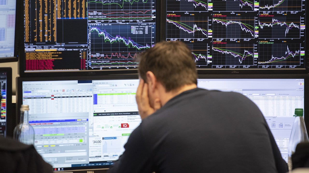 Ein Börsenhändler an der Frankfurter Börse blickt auf seine Monitore.