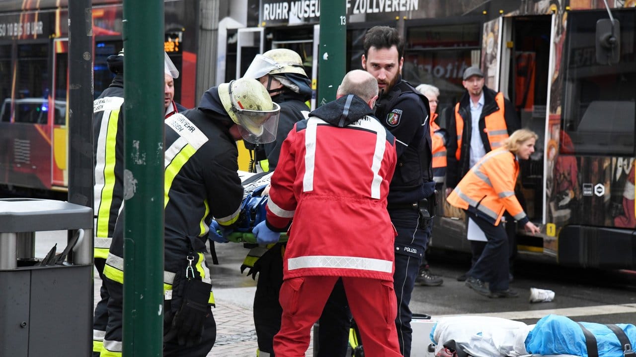 Einsatzkräfte versorgen Verletzte, nachdem eine Seniorin in Essen an einer Straßenbahn-Haltestelle in eine Menschenmenge gefahren war. Einsatzkräfte versorgen Verletzte, nachdem eine Seniorin in Essen an einer Straßenbahn-Haltestelle in eine Menschenmenge gefahren war.