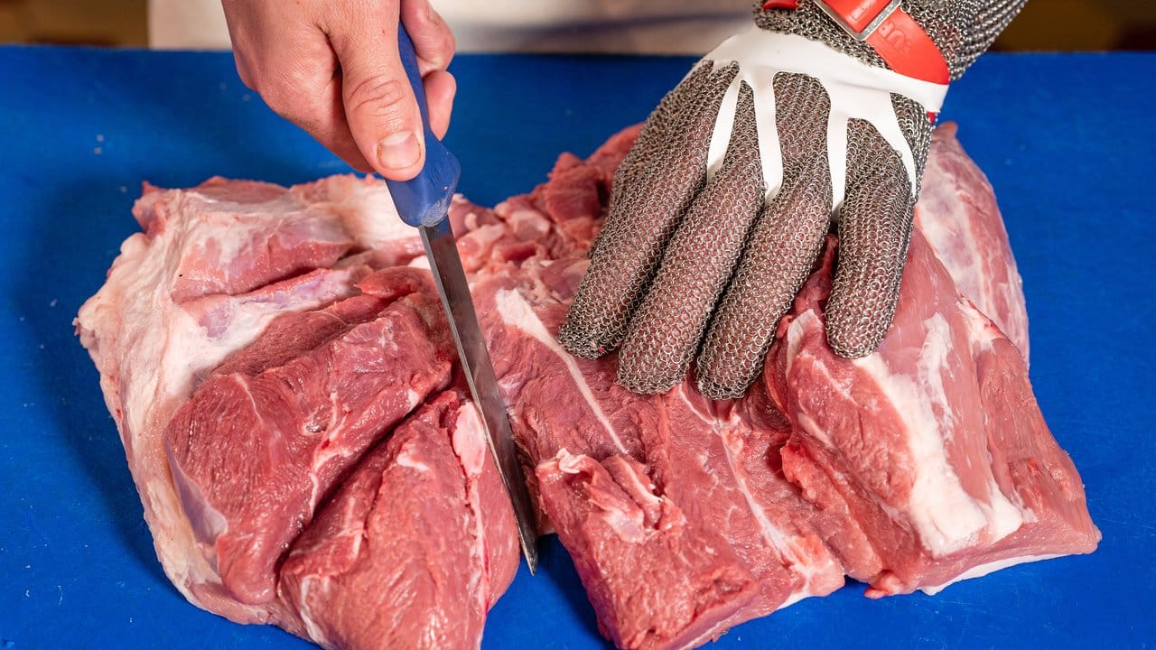 Ein Kettenhandschuh schützt: Der angehende Fleischer Maurice Münch lernt, worauf es beim Zerteilen von Fleisch ankommt.
